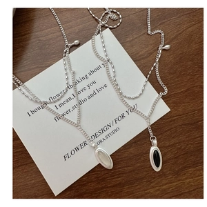 Macro detail of S925 silver double-layer necklace with vintage teardrop moonstone pendant