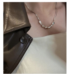 Macro detail of silver necklace featuring five irregular hammered texture metal beads
