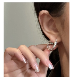 Close-up of liquid silver S925 sterling silver earring with minimalist fluid design on model