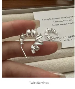 Vue macro de la boucle d'oreille torsadée en argent S925 avec finition brossée mate