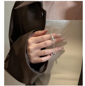 Detailed close-up of a silver Y-shaped heart pendant necklace worn on a model