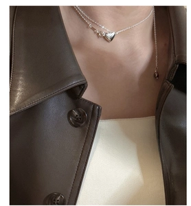 Detail of S925 sterling silver heart necklace with zircon and double layered chain on model