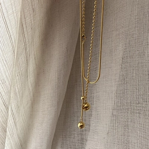 Double-layered gold ball pendant necklace featuring sleek snake and bead chain styles