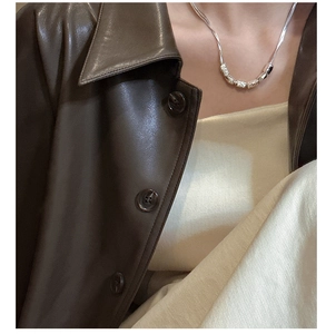 Close-up of S925 sterling silver beaded necklace on model wearing a leather jacket
