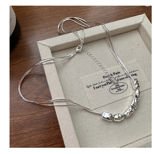 Macro shot of multi-layer S925 silver necklace with irregular beads and Silver tag