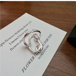 Detail of S925 sterling silver twisted ring with irregular texture on white card