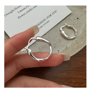 Close-up of S925 sterling silver stamp on liquid-style minimalist hoop earrings
