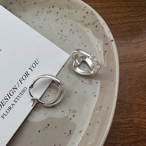 Elegant S925 sterling silver hollow heart earrings with polished finish on a ceramic plate