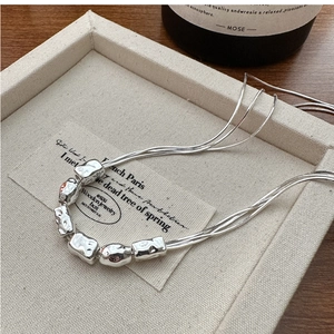 Detail view of S925 silver necklace with multi-strand chains and textured hammered beads