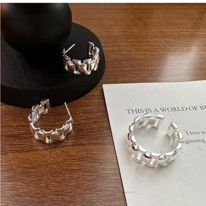 Detail of silver tank chain jewelry set featuring a C-shaped earring and adjustable ring