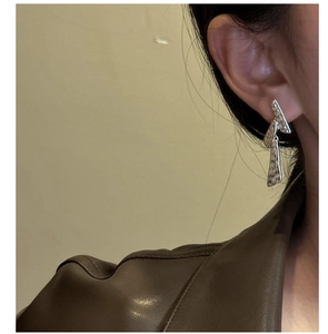 Gros plan de boucles d'oreilles pendantes en argent S925 avec texture martelée sur modèle