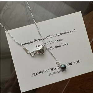 Detail of silver S925 necklace with 3D heart pendant and black pearl on white card