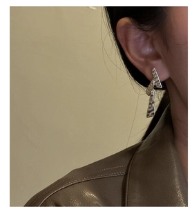 Détail de boucles d'oreilles pendantes S925 argentées texturées portées par un mannequin