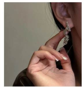 Détail de boucles d'oreilles en argent S925 avec texture martelée et design géométrique