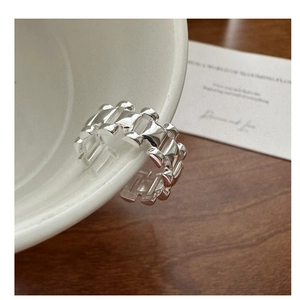 Vue détaillée d'une bague en argent style bracelet de montre sur une tasse blanche