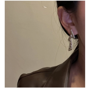Détail de boucles d'oreilles en argent S925 à texture martelée sur un mannequin