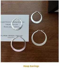 Gros plan détaillé de créoles en argent sterling S925 avec une texture mate brossée