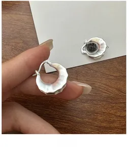 Detailed view of matte S925 sterling silver hoop earrings with unique wavy cloud edges