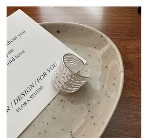 Dettaglio di anelli d'argento con trama multistrato su un vassoio di ceramica