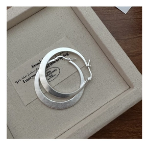 Vue détaillée des créoles en argent sterling S925 avec une finition à texture mate brossée