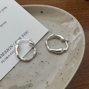 Minimalist S925 sterling silver liquid wave earrings on a ceramic tray display