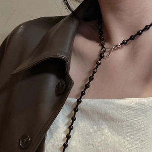 Close-up of s925 silver infinity clasp on a long beaded obsidian sweater necklace