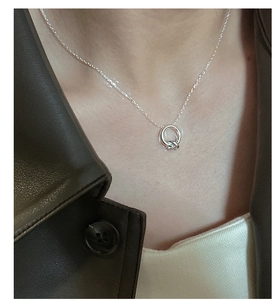 Dettaglio della collana minimalista con nodo in argento S925 indossata su giacca in pelle