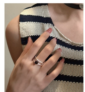 Detail of S925 silver double-layered ring with a round black onyx stone on a finger