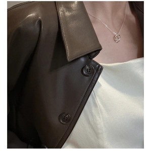 Dettaglio della collana in argento sterling S925 con nodo su una giacca di pelle