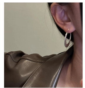 Gros plan sur de grandes créoles en argent sterling S925 portées par un mannequin