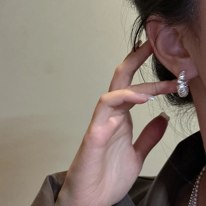 Boucles d'oreilles spirales minimalistes en argent S925 mat portées par un mannequin