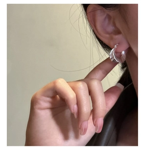 Close-up of S925 sterling silver hoop earring with irregular vertical pleated texture