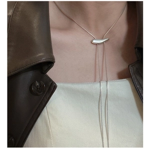 Gros plan du pendentif haricot en argent S925 sur une longue chaîne pull ajustable en Y