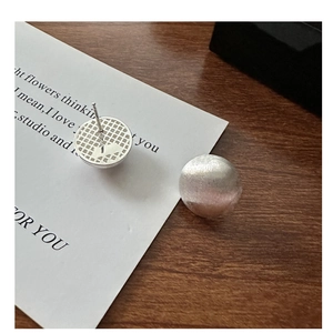 Detail showing the brushed S925 silver spherical stud earring with its textured back plate