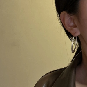 Créoles minimalistes en argent sterling S925 avec finition mate sur un modèle féminin