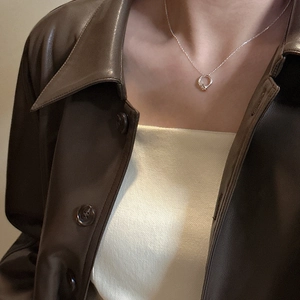 Elegante collana in argento sterling S925 con pendente a cerchio annodato su una modella