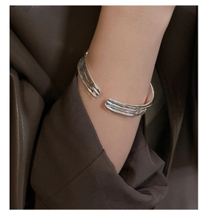 Close-up of S925 sterling silver open bangle with textured multi-layer design on wrist