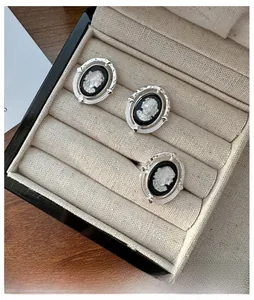 Vue détaillée de trois bagues camée vintage avec portraits en relief blanc sur boîte à bijoux