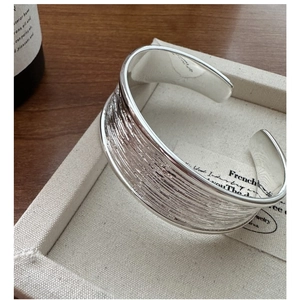 Close-up of S925 sterling silver cuff bracelet with vintage brushed metal texture