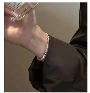 Minimalist S925 sterling silver chain bracelet shown on model wrist with leather jacket