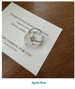 Dettaglio macro dell'anello d'argento multistrato con agata bianca su un biglietto regalo