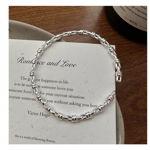 Detail view of silver twisted knot texture on a C-shaped open bangle bracelet