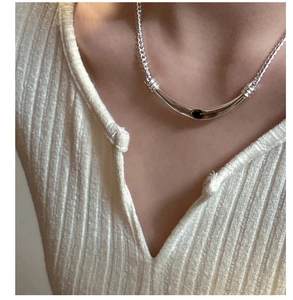 Détail d'un collier en argent S925 avec pendentif en agate noire sur le cou d'un modèle