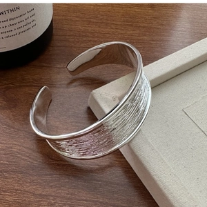 Detailed view of wide silver S925 cuff bracelet featuring unique hammered texture and mirror finish