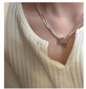 Dettaglio della collana a tre strati in argento S925 con ciondolo a cubo martellato