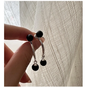 Gros plan de boucles d'oreilles pendantes en argent S925 avec perles d'agate noire