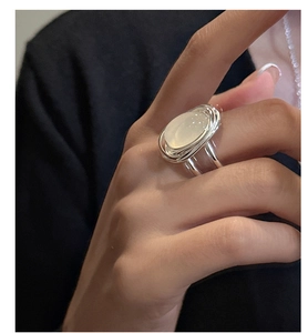 Dettaglio anello in argento S925 con agata bianca e design multi-filo sulla mano di donna