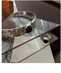 Makroaufnahme von Silberschmuck-Set mit Hammerschlag-Textur und schwarzen Achaten
