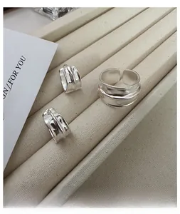 Detailed close-up of S925 sterling silver liquid metal style ring and earring set on a display