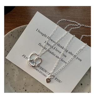 Macro shot of S925 sterling silver pretzel pendant with heart tag on decor card
